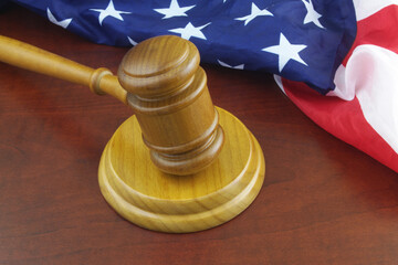 Wooden judge gavel and USA flag. Laws and court of US concept.