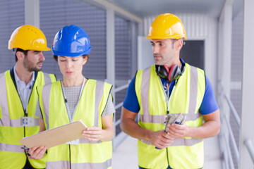 Supervisors and worker with clipboard talking in factory