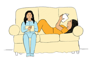 Two women sitting on couch and reading books