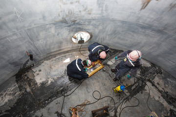 Top view male worker inspection vacuum test tank petrochemical steel weld leak