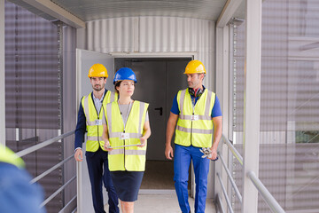 Supervisors and worker with clipboard talking in factory