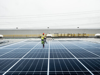  male engineer checks a photovoltaic (solar) plant and uses a recording tablet. mechanic in protective helmet. Man in uniform holding tablet.