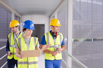 Supervisors and worker with clipboard talking in factory