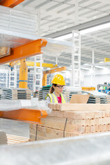 Female worker using laptop in factory