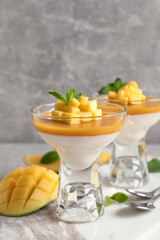 Delicious panna cotta with mango coulis served on light grey table