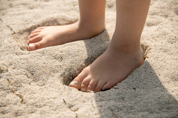 Obraz na płótnie Canvas Füße von Kleinkind stehen im Sand am Meeres Strand.