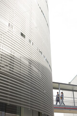 Supervisors walking on elevated walkway between factory buildings