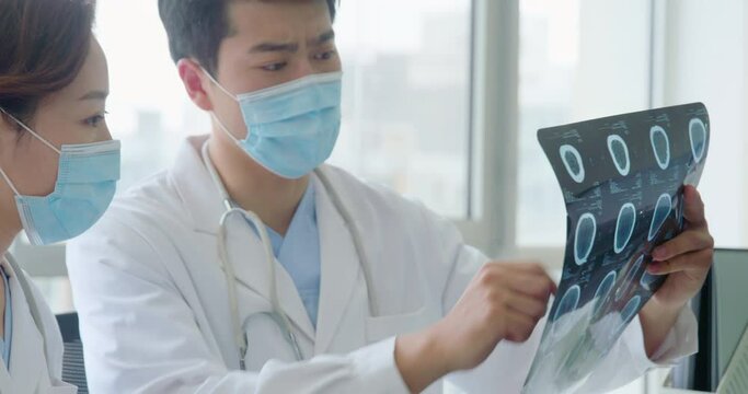 Young doctors discussing X-ray image,4K