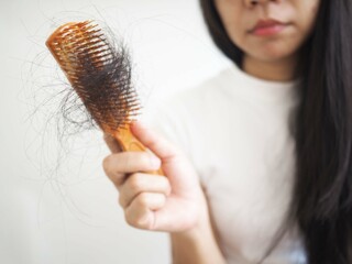 Woman worried about hair loss problem on white background. closeup photo, blurred.