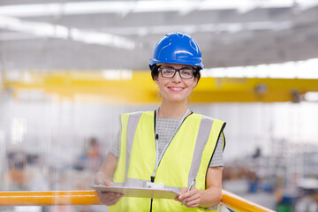 Portrait confident female supervisor with clipboard in steel factory