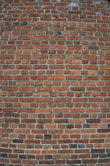 red brick wall with several dark bricks. Texture. Background. vertical photo