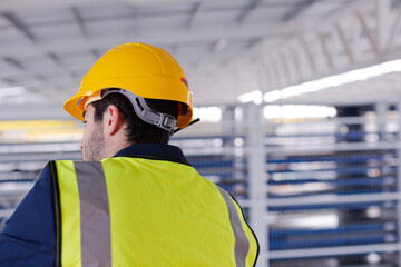 Male supervisor using walkie-talkie on platform in factory