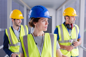 Supervisors and worker with clipboard in factory