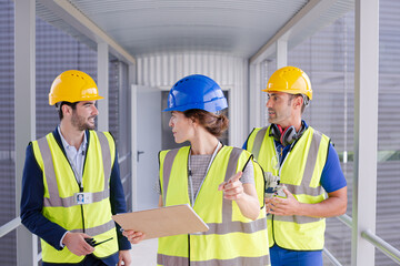 Supervisors and worker with clipboard in factory
