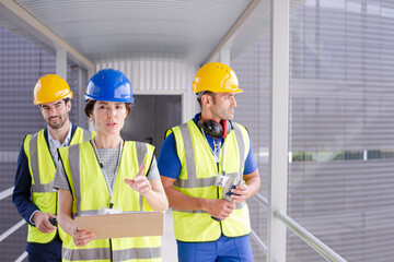Supervisors and worker with clipboard talking in factory