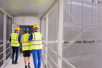Supervisors and worker walking in factory