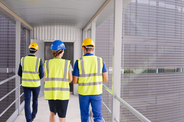 Supervisors and worker walking in factory