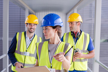 Supervisors and worker with clipboard in factory