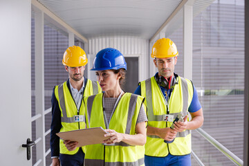 Supervisors and worker with clipboard in factory