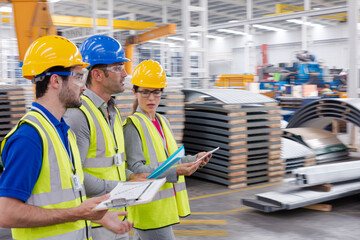 Workers talking in steel factory