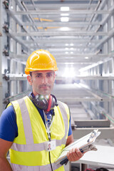 Fototapeta na wymiar Portrait confident worker with clipboard in steel factory