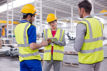 Supervisor and workers talking in steel factory