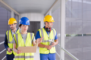 Supervisors and worker with clipboard talking in factory