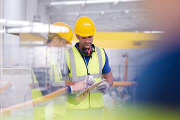 Supervisor and worker talking in steel factory
