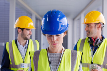 Supervisors and worker with clipboard in factory