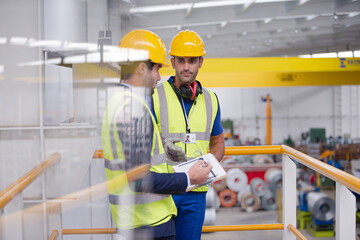 Supervisor and worker talking in steel factory