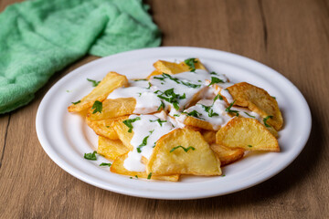 Traditional delicious Turkish foods, fried potatoes with yoghurt (Turkish name; Yogurt soslu patates kizartmasi)
