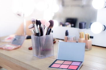 Close-up Powder set without foundation or pressed powder color gradation in square, makeup brushes and skin creams, on the dressing table with a mirror.