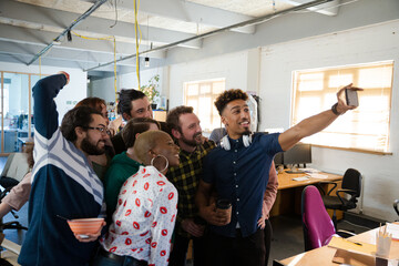 Team taking group selfie in office
