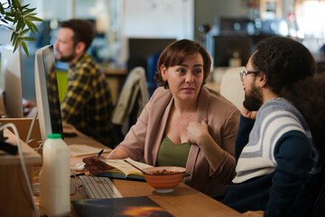 People working at desk, talking