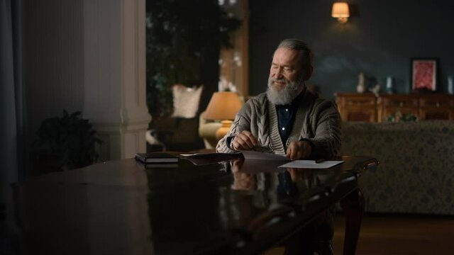 Senior Business Man Working With Papers On Table In Luxury House