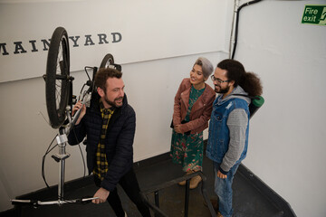 Friends carrying bicycle up stairwell
