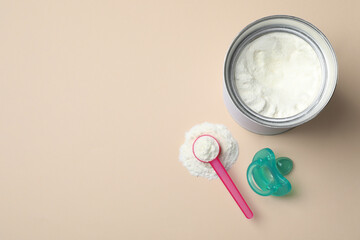 Flat lay composition with powdered infant formula on beige background, space for text. Baby milk