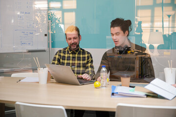 Colleagues working together at laptop in conference room