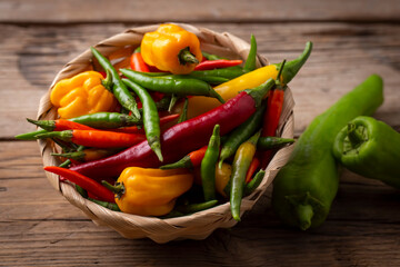 Colorful hot peppers on wooden background