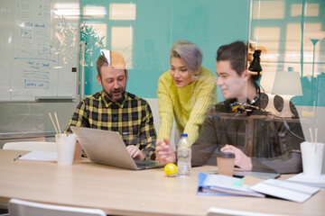 Three colleagues working at computer in conference room