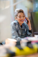 Young woman talking on cell phone in office