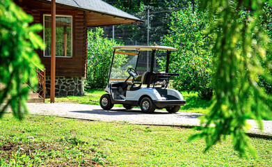 White golf cart in the parking lot near the building.