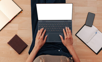 Woman working behind laptop with white screen sitting on floor