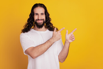 Portrait of handsome attractive brunet man indicate finger blank space on yellow background