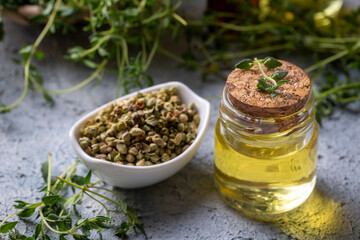A bottle of thyme essential oil with fresh thyme