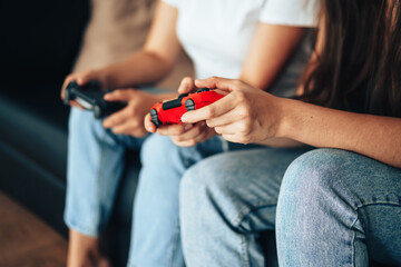 Girls holding gamepads and playing video games on the console.