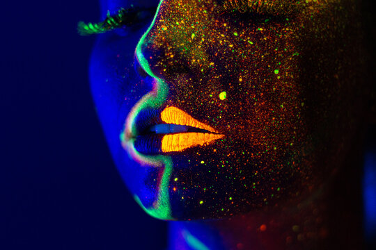 UV light portrait woman with golden powder and glowing fluorescent lines