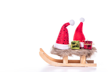 Ein Schlitten mit Geschenke und Weihnachtsmütze vor einem Weißen Hintergrund