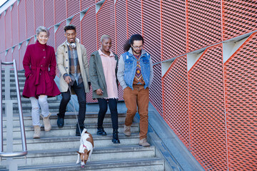 Fototapeta premium Young friends walking down down urban, modern stairs