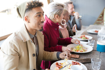 Smiling friends eating at restaurant outdoor patio